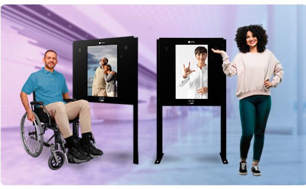 acessibilidade-imply-totem-interativo Dois totens de tela de toque com imagens de pessoas sorrindo, uma mulher em cadeira de rodas e uma mulher sinalizando em linguagem de sinais.