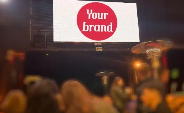 Painel publicitário iluminado em cidade à noite