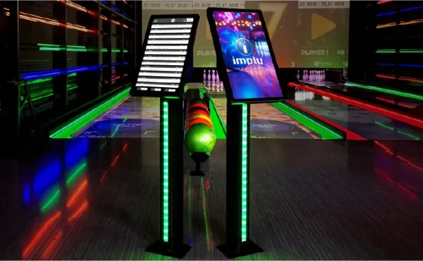 Pista de bowling com iluminação neon e pinos ao fundo, garrafa de bola e telas de pontuação no placar, simulando um ambiente de boliche moderno e vibrante.