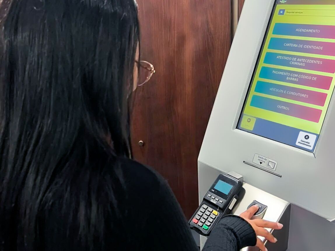 Usuária utilizando caixa eletrônico para serviços bancários